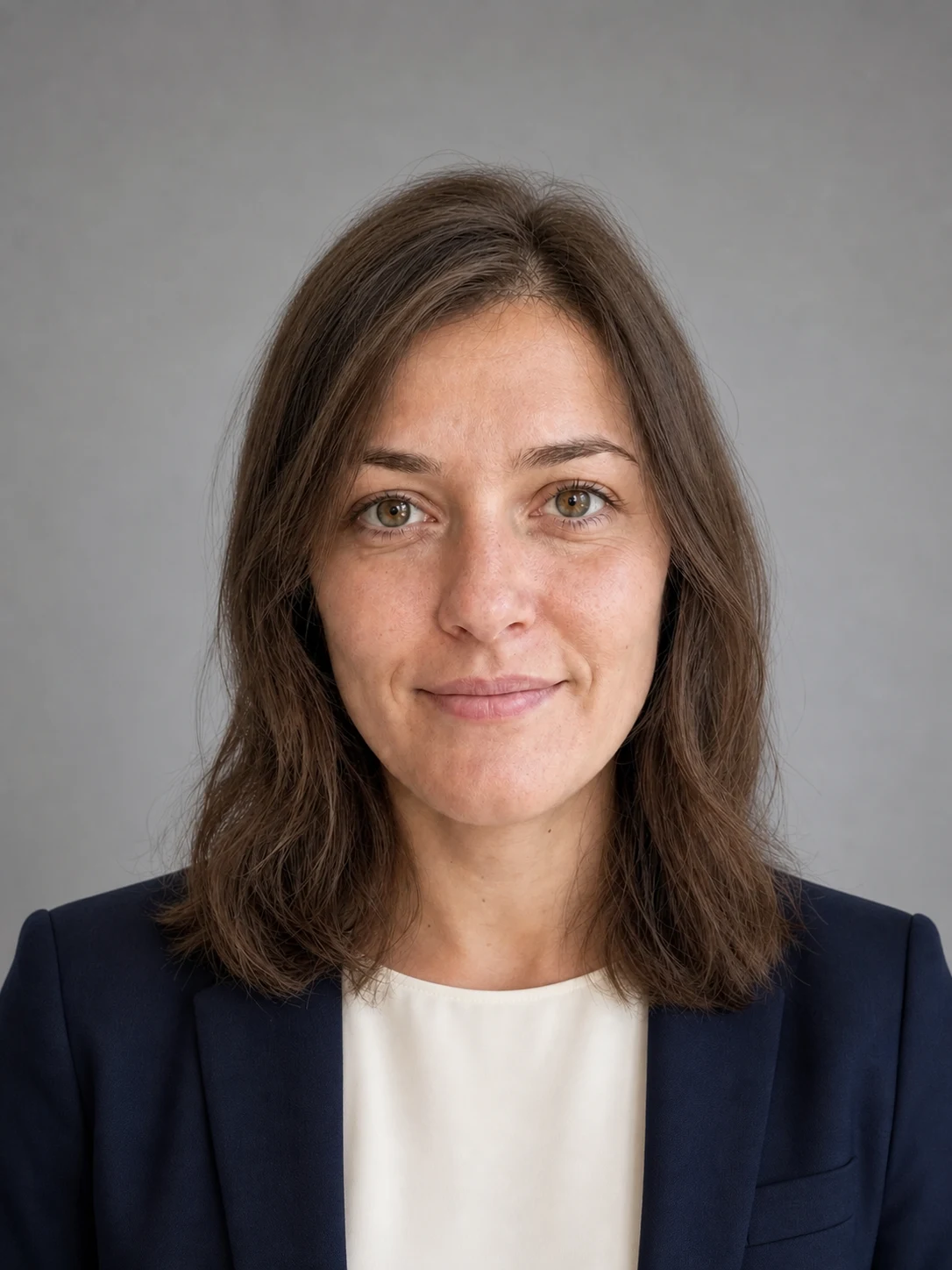 Professional corporate headshot with a navy blazer and calm studio background