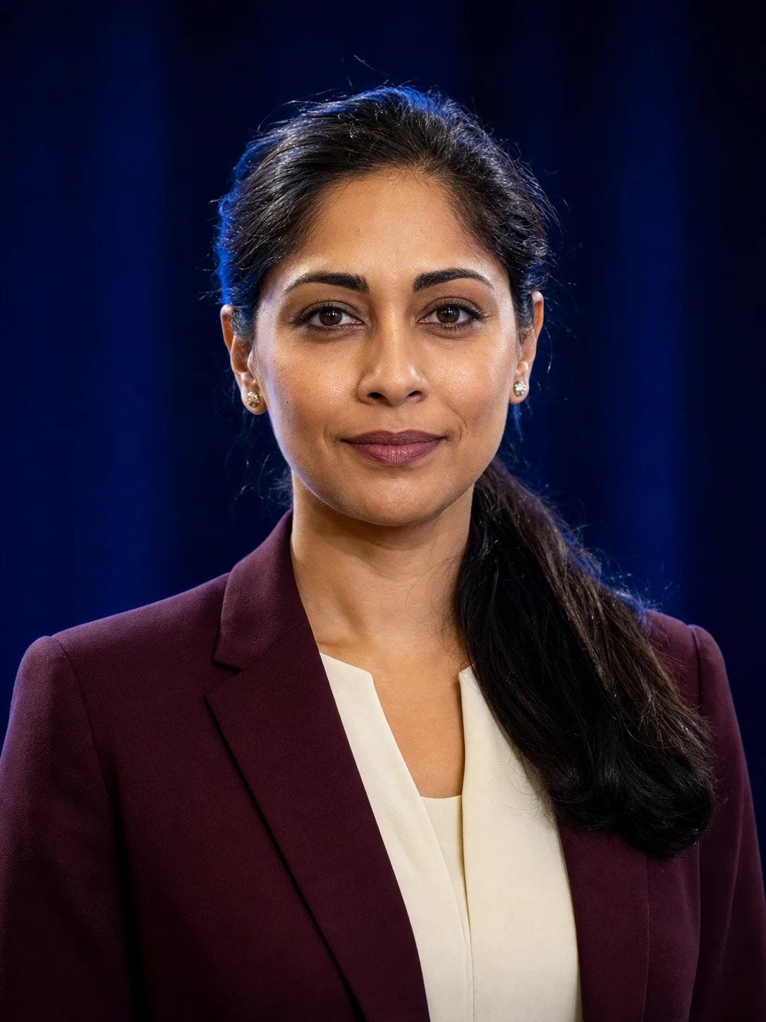 Confident conference speaker headshot with a softly blurred stage background